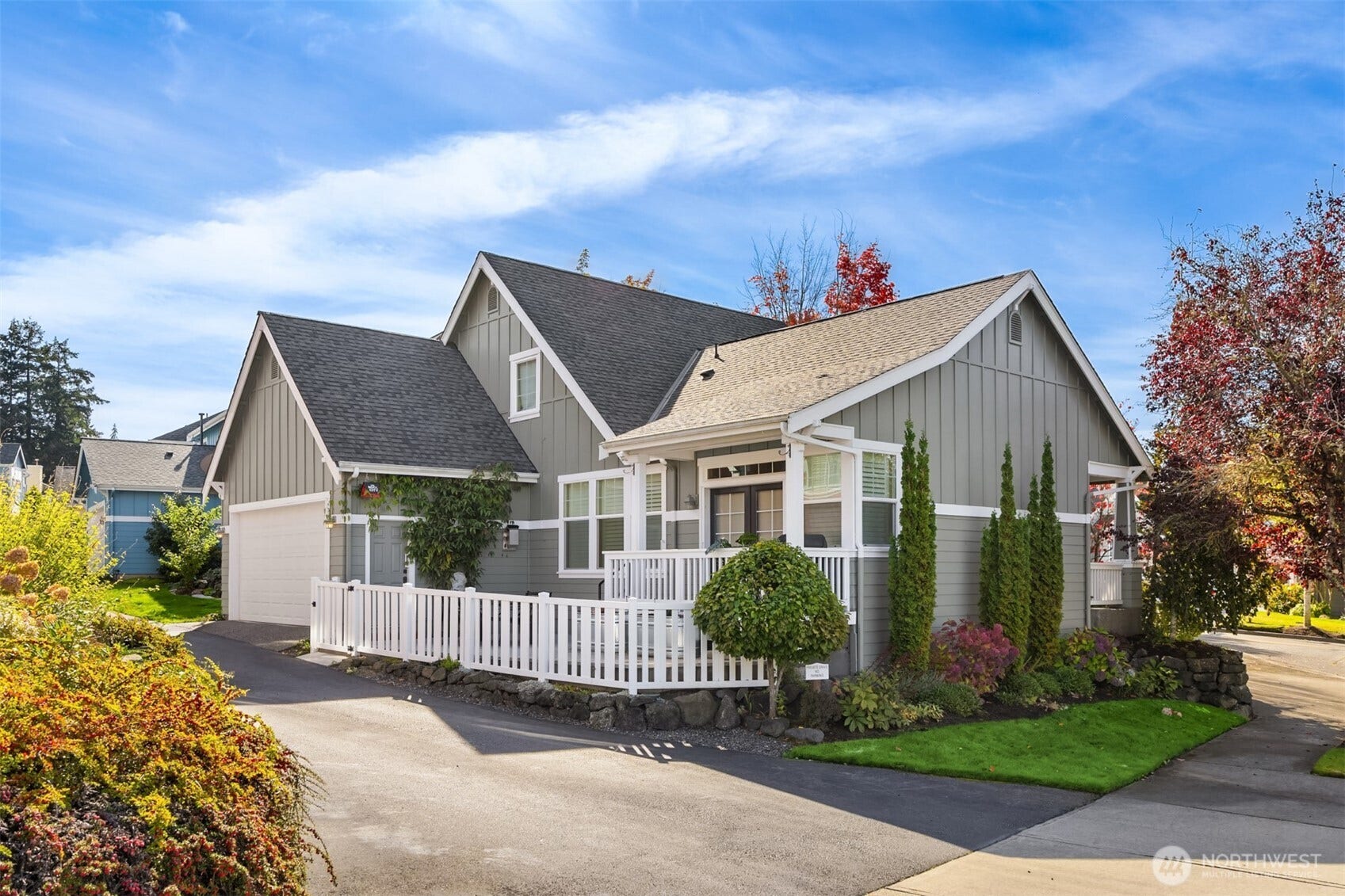 19800 Jensen Way NE, Poulsbo, WA 98370 Crisp white trim, classic gables, and a welcoming covered porch complement the homes gray exterior, while established landscaping adds year-round appeal.