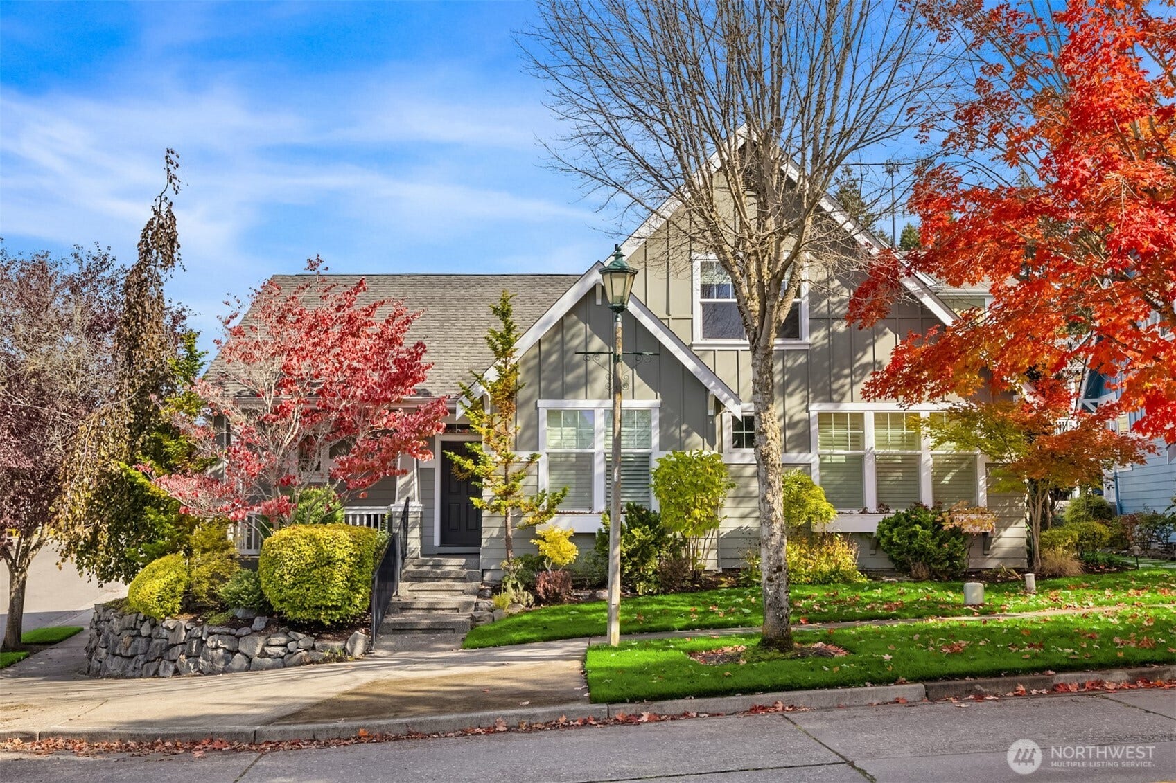 19800 Jensen Way NE, Poulsbo, WA 98370 Framed by colorful maples and lush landscaping, this inviting home pairs timeless architectural details with a covered entry and handsome stone retaining wall.