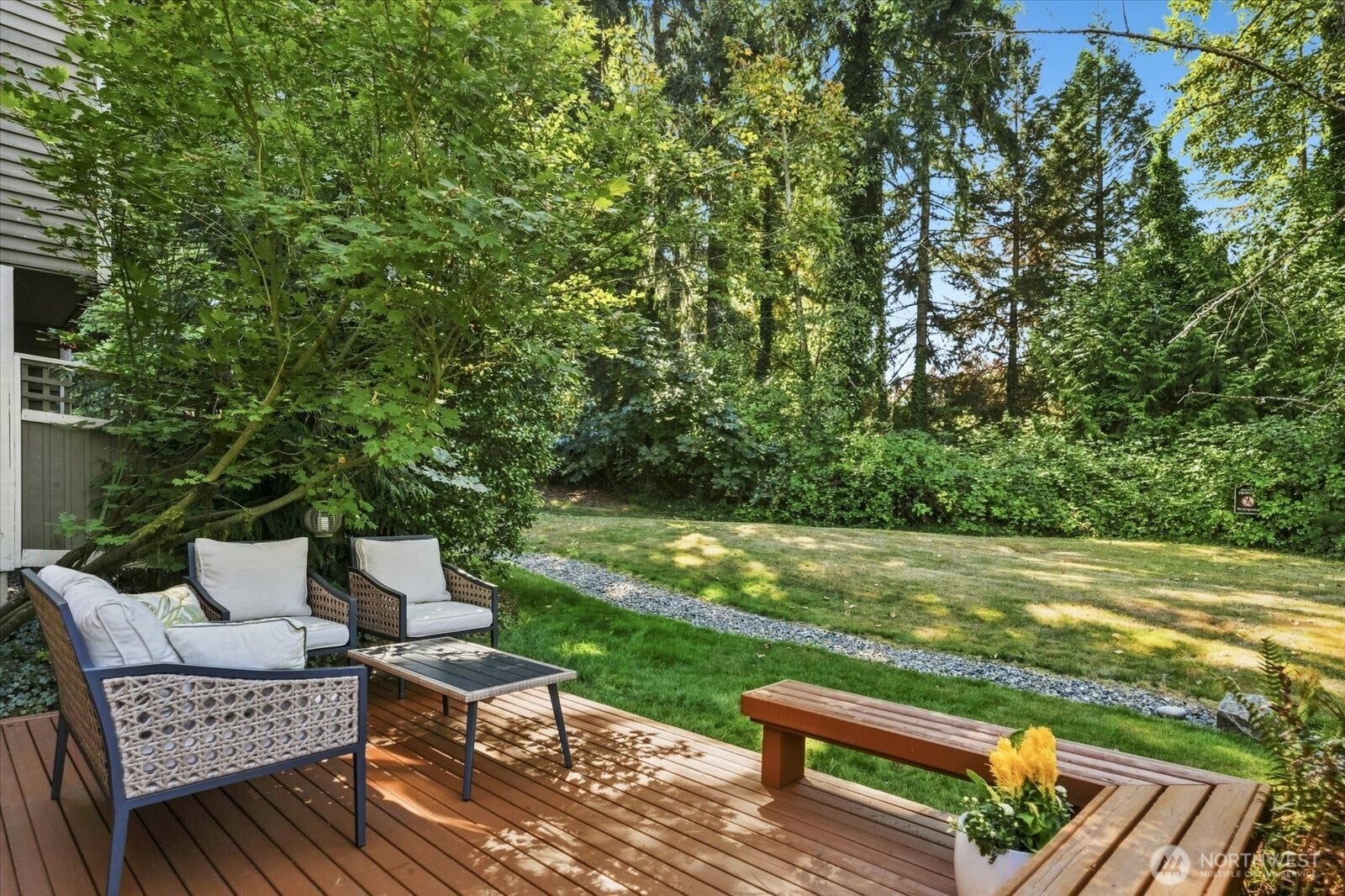 11411 102nd Court NE, Kirkland, WA 98033 Private deck, freshly stained, overlooks lush green space, creating a peaceful setting for outdoor dining or relaxing.