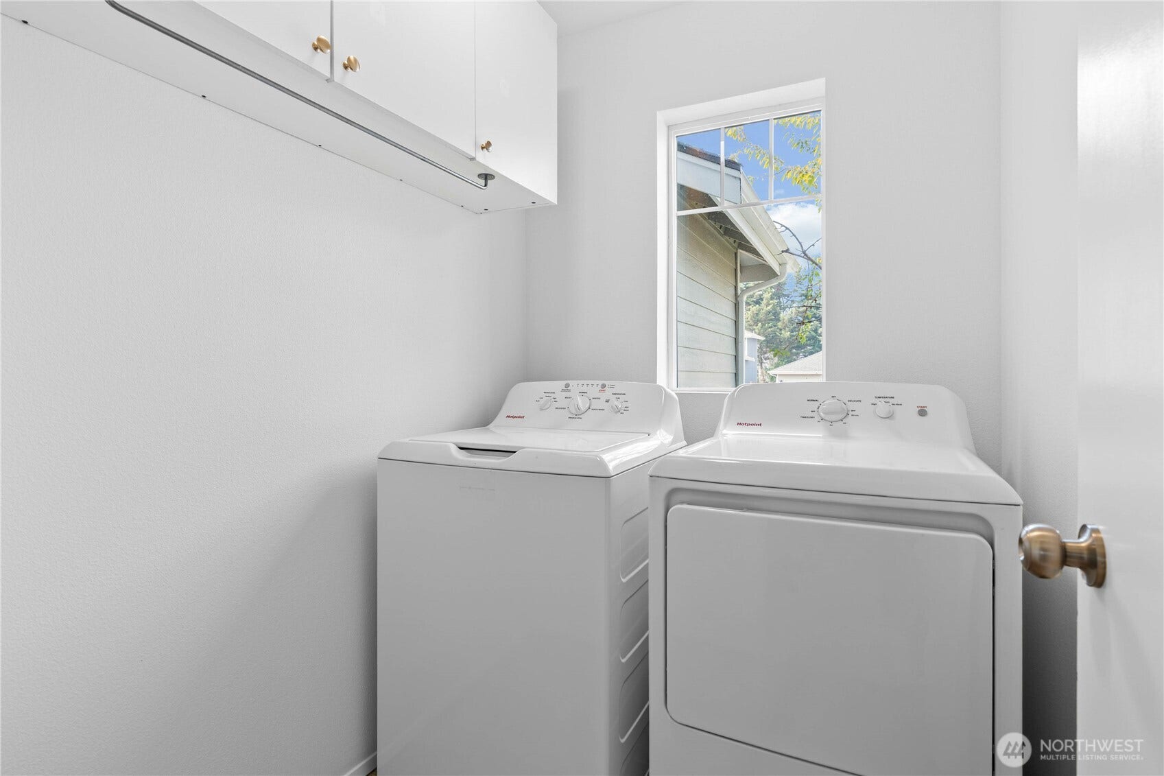 The laundry room makes everyday routines and unloading a breeze. Built-in cabinetry and a hanging rod provide practical organization for household essentials.