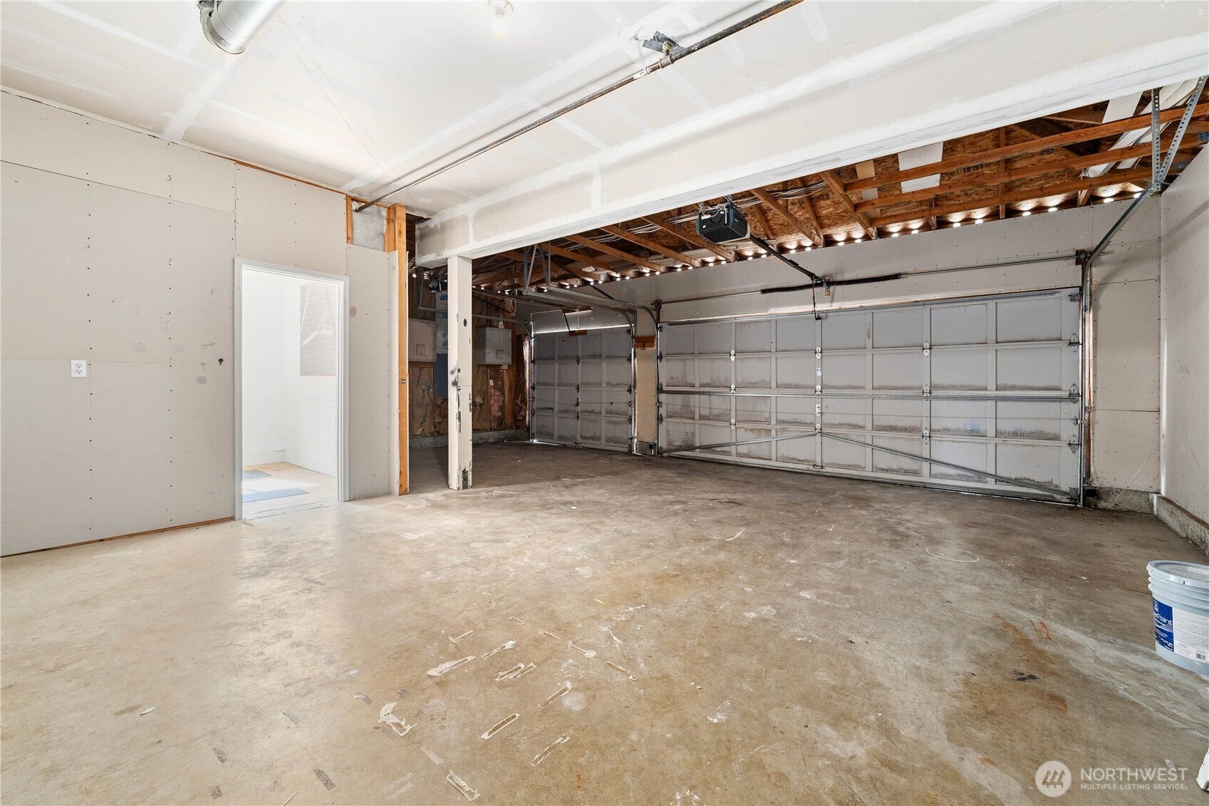 This photo shows the inside of the three-car garage that includes the finished flex room in the back portion of the third bay. It provides exceptional room for storage, hobbies, and/or weekend projects. There is still room outside the flex room for a small vehicle, motorcycles, recreational equipment, as there is approximately 13 feet between the flex room and the garage door. Bring your tape measurer and see for yourself!