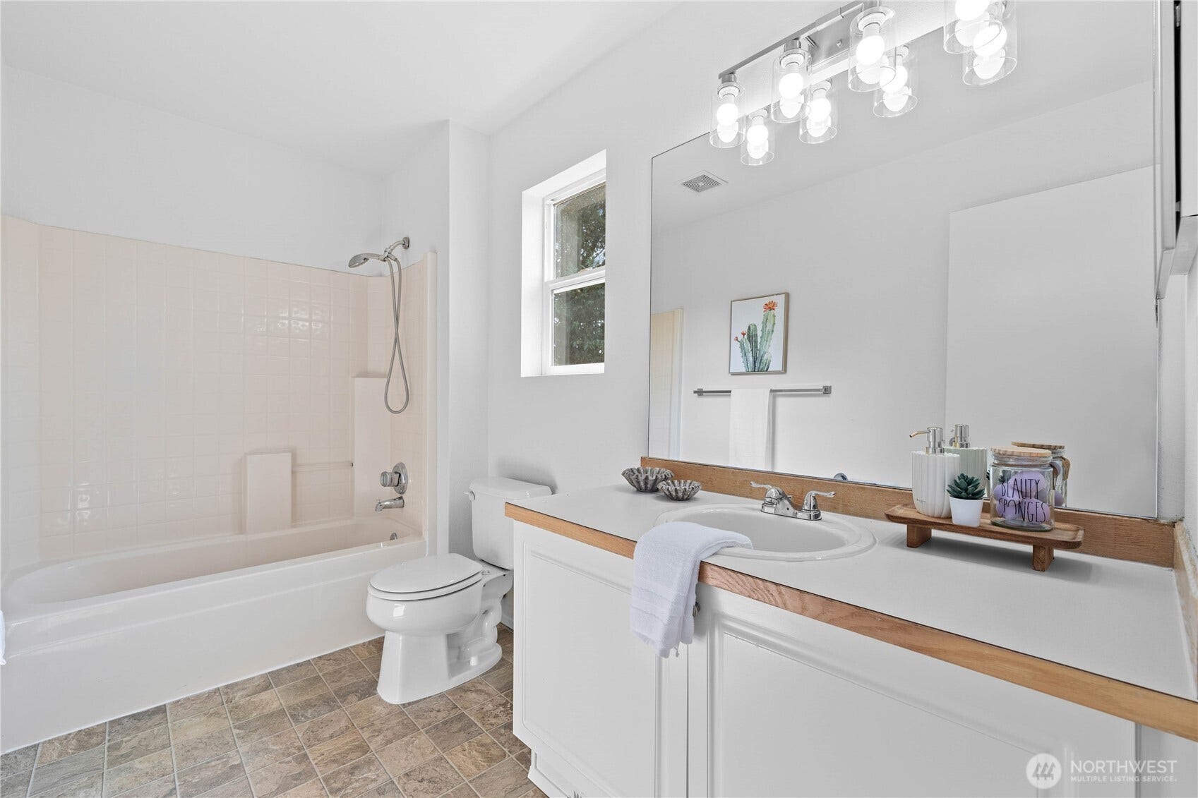 The full bathroom upstairs features a spacious vanity with generous counter and cabinet storage, large mirror and timeless lighting. Note that the tub/shower combination features the look of tile but the ease of fiberglass. A double win!