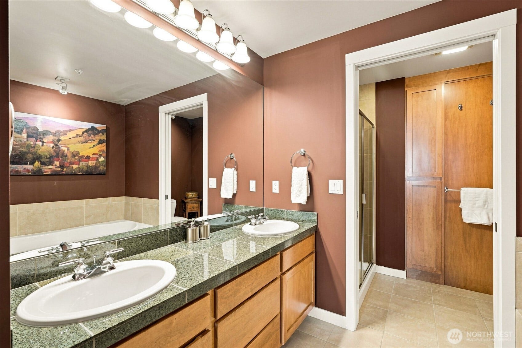 2607 Western Avenue, #1002, Seattle, WA 98121 The spacious primary bath offers a spa-like retreat with a large soaking tub, double vanity, and generous tile finishes. A two-headed tiled shower and private water closet are thoughtfully separated by a convenient sliding pocket door, creating privacy and a functional layout.