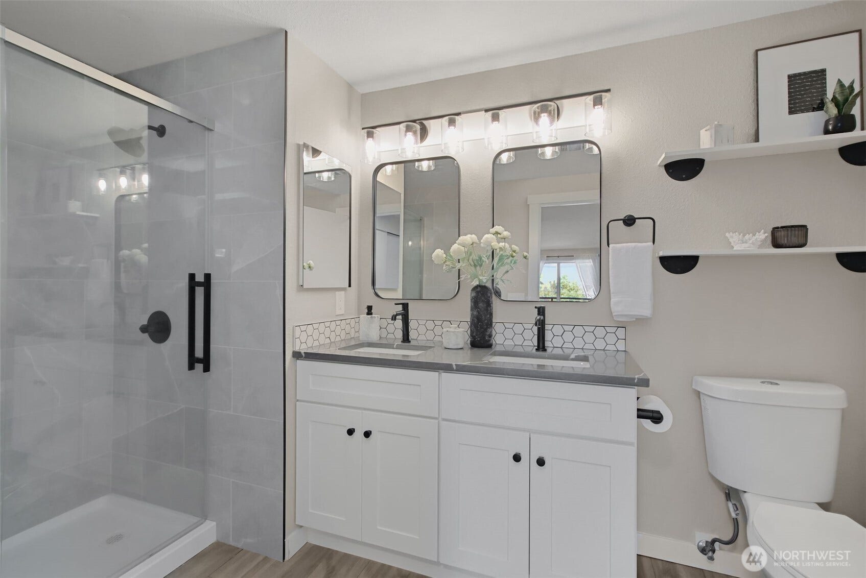 Completely updated bathroom with chic lighting, tile and matte black finishes