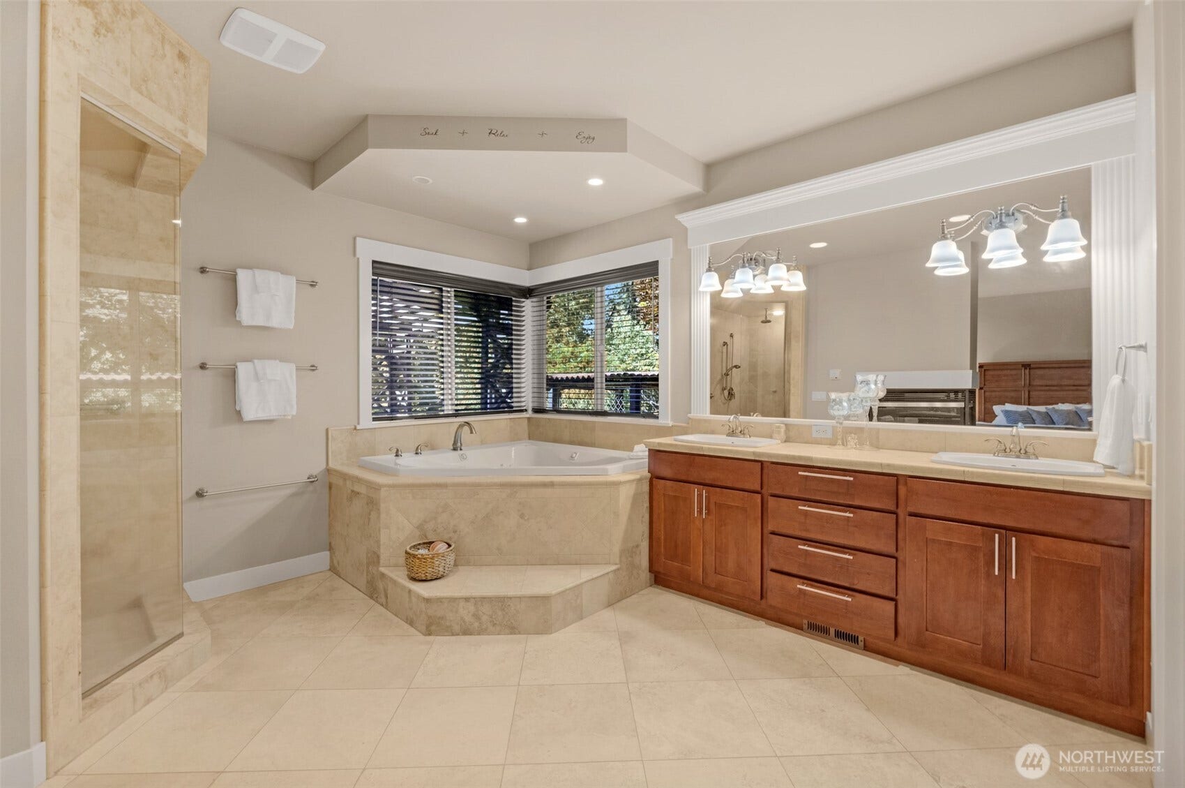 Primary luxury bathroom with jetted tub and separate shower.