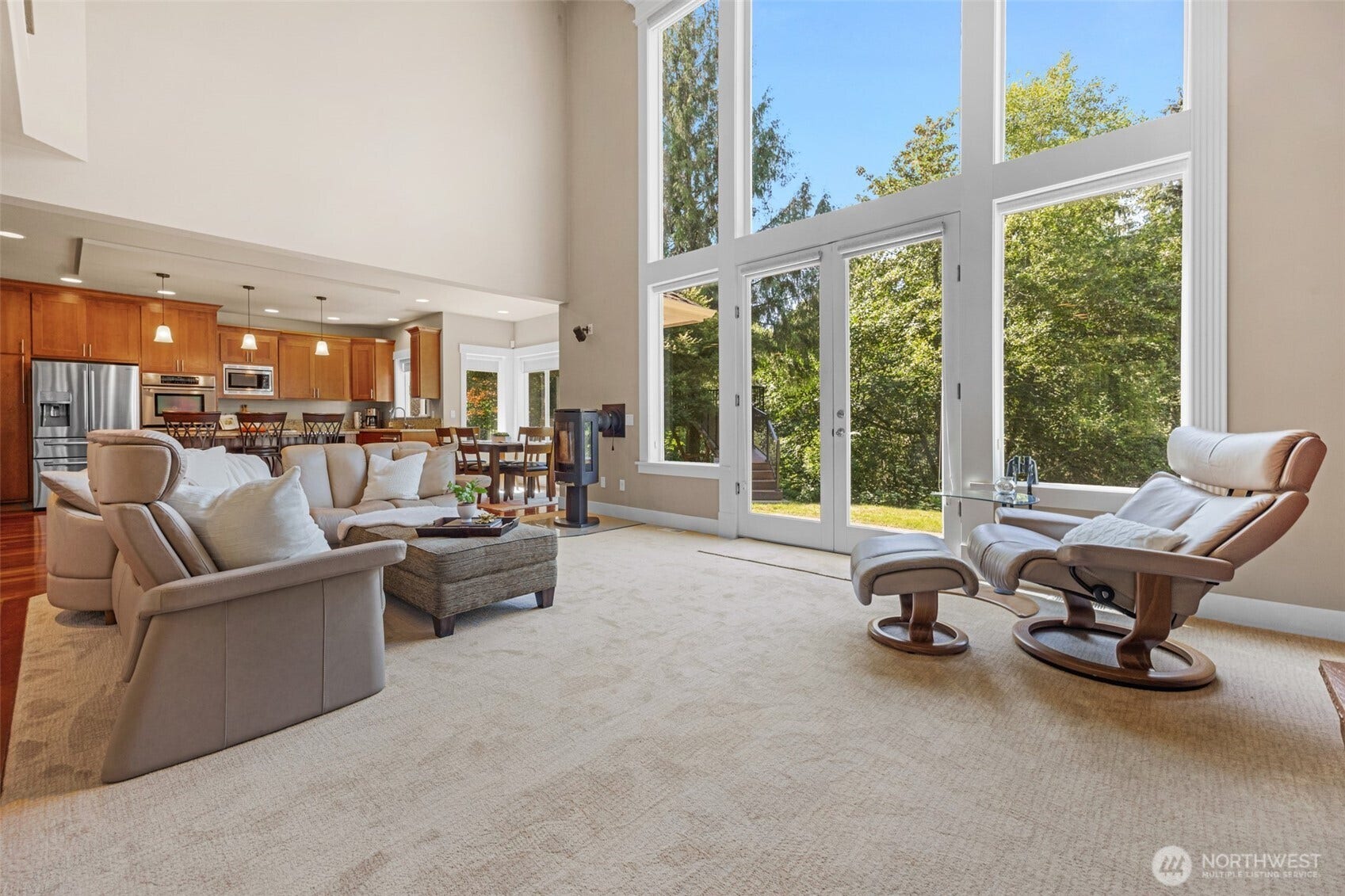 Living room framed by wall of windows that bring nature inside