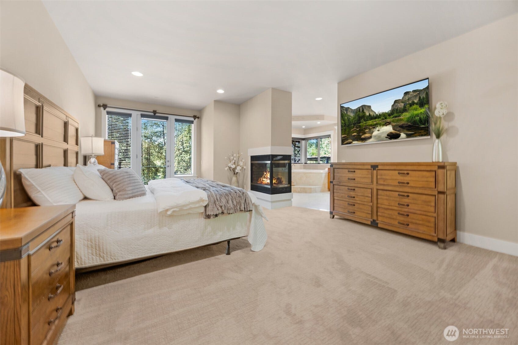Spacious primary suite with patio access, gas fireplace, and luxury bathroom.