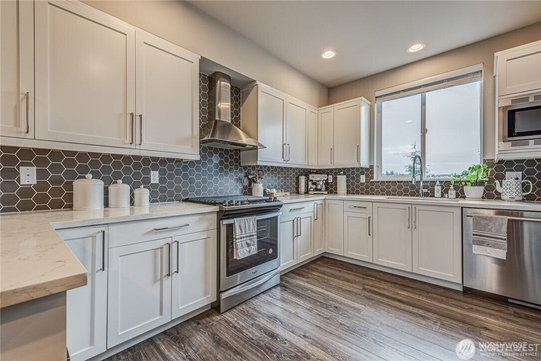 Kitchen with stove, dishwasher, refrigerator and microwave.