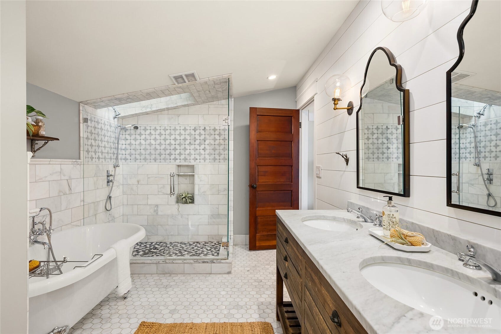 8405 Hansen Road NE, Bainbridge Island, WA 98110 The primary bathroom with marble finishes, claw foot tub and walk-in shower with skylight.