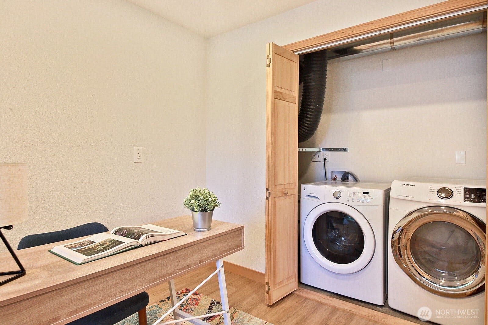The newer hybrid water heater and washer & dryer are located in the closet in this office/flex space.