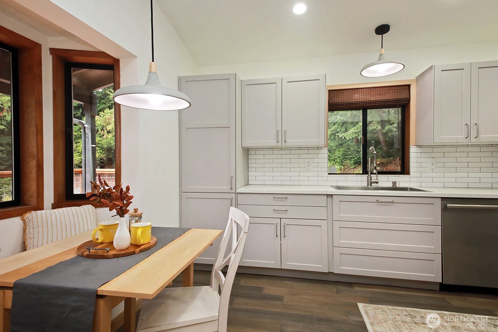 Along the left edge of the photo, a sweet window seat, perfect spot for a smaller kitchen table. All new cabinets, flooring lighting and a newer dishwasher!