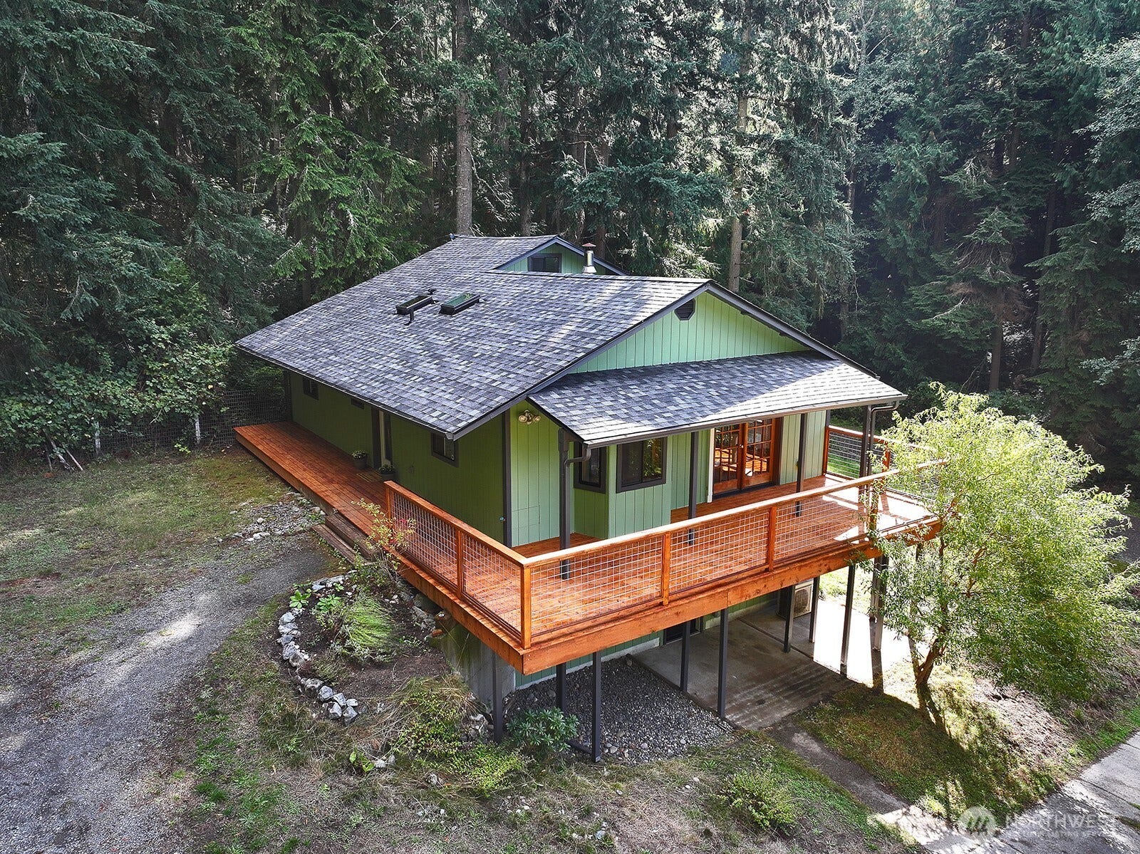 Newer deck with a portion of it covered. French doors open from the living room/dining area out onto the deck. Entrance to the lower level is under the deck. The Olympic Mountains are viewed on a clear day from the deck!
