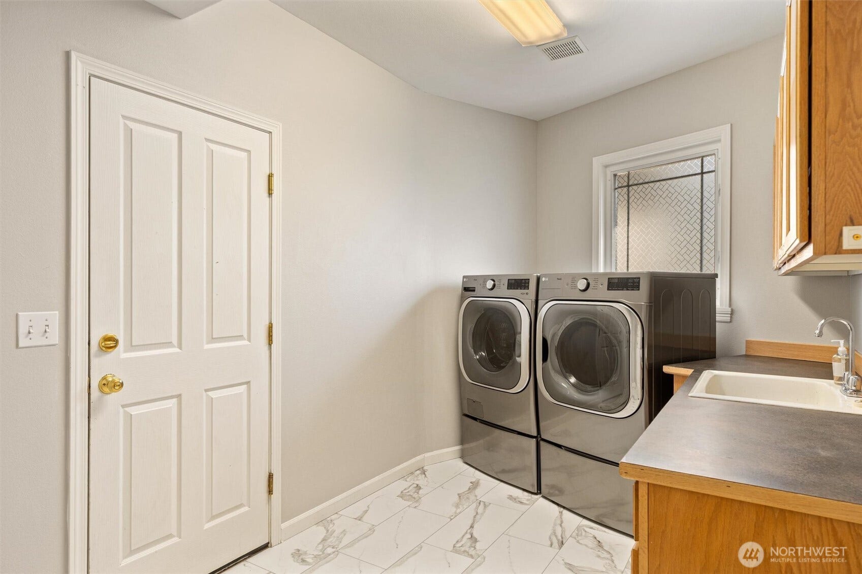 19141 148th Avenue NE, Woodinville, WA 98072 Large Utility room inside garage door with ample storage and utility sink.