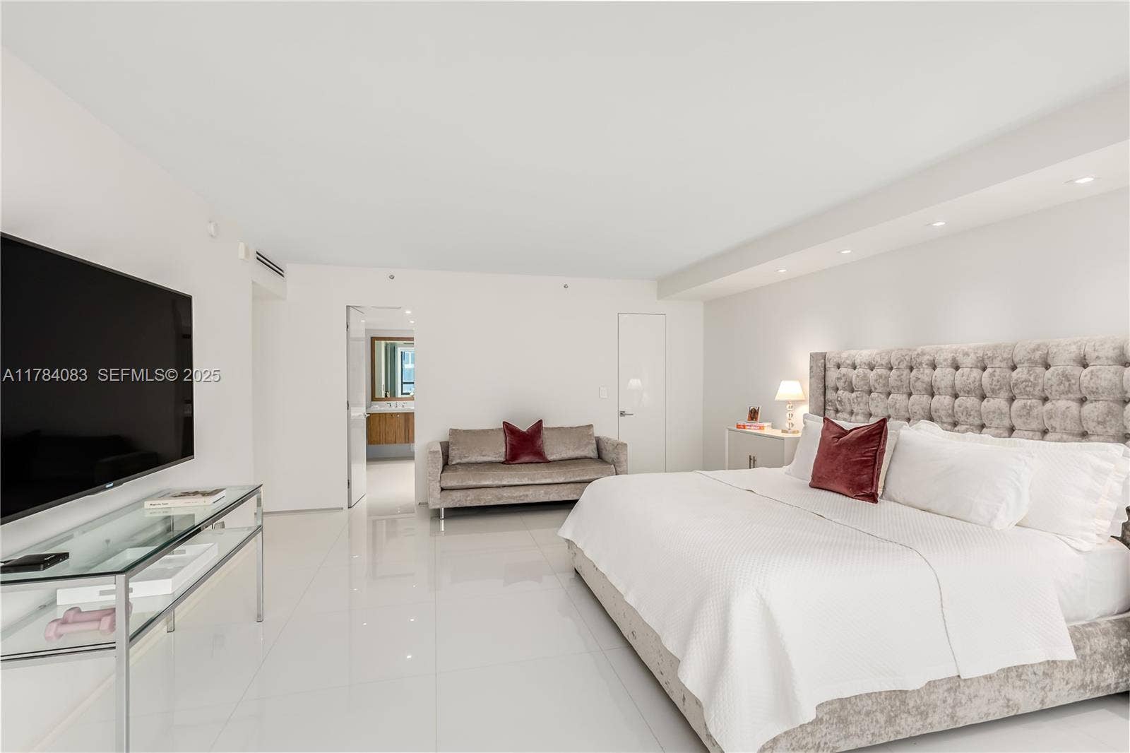 Enormous primary bedroom suite with seating area and walk in closets.