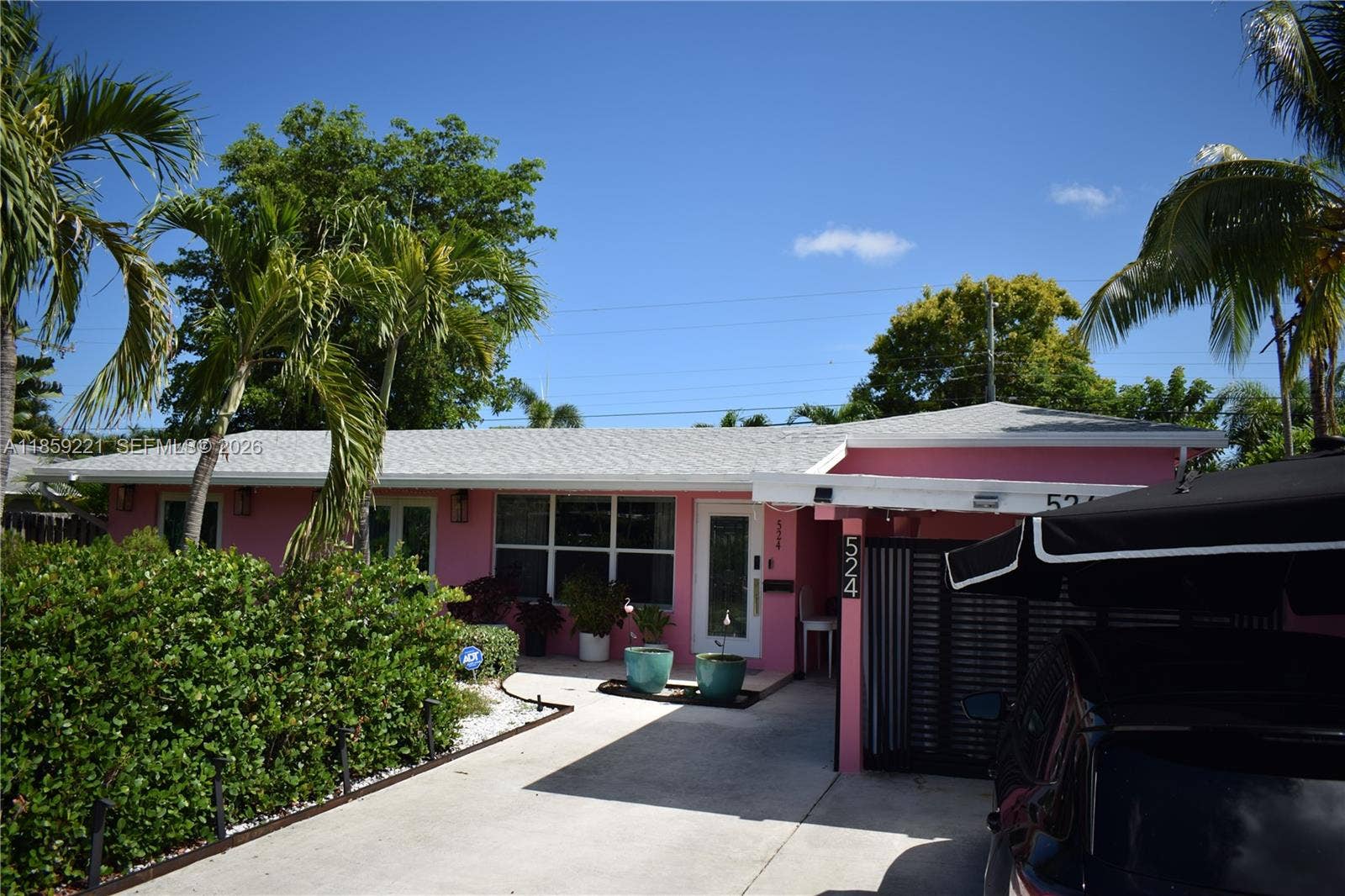 524 NE 27th Drive, Wilton Manors, FL 33334 Lush hedges frame the property with integrated lights that softly illuminate the walkway, offering both charm and direction to the front door