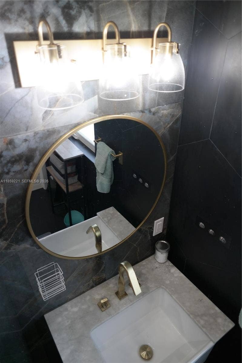 524 NE 27th Drive, Wilton Manors, FL 33334 Contemporary bathrooms include upgraded deep sinks with elegant golden faucets and fixtures for modern and chic aesthetic.
