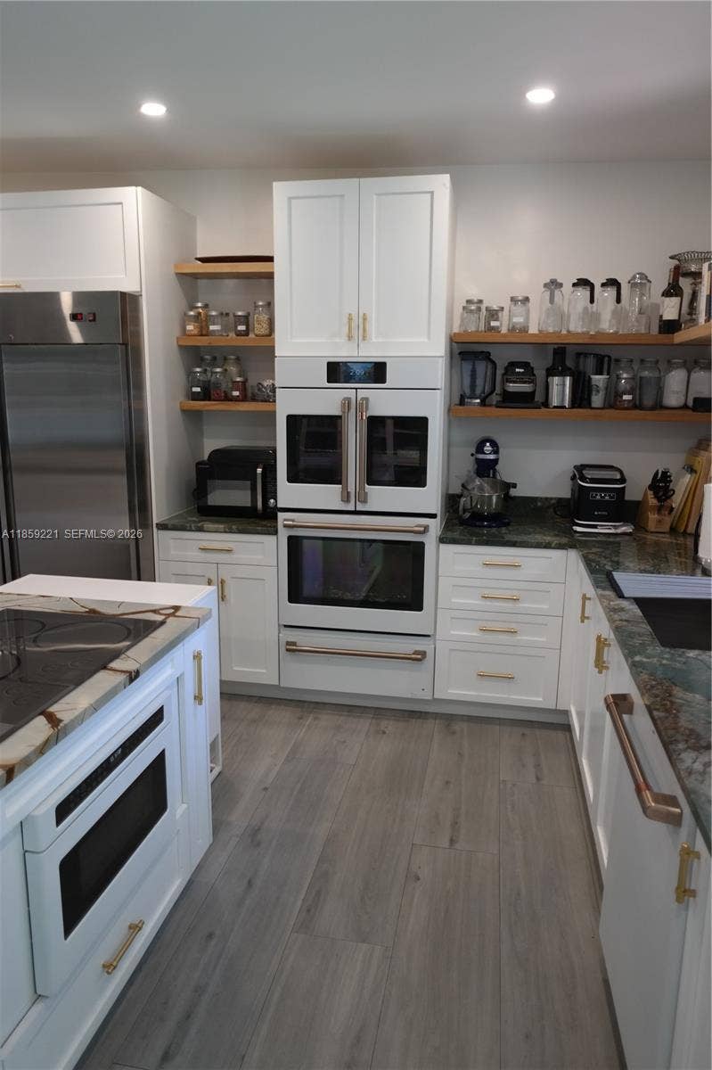 524 NE 27th Drive, Wilton Manors, FL 33334 Crisp white fixtures match flawlessly with the cabinetry, featuring sleek handles that elevate the overall design