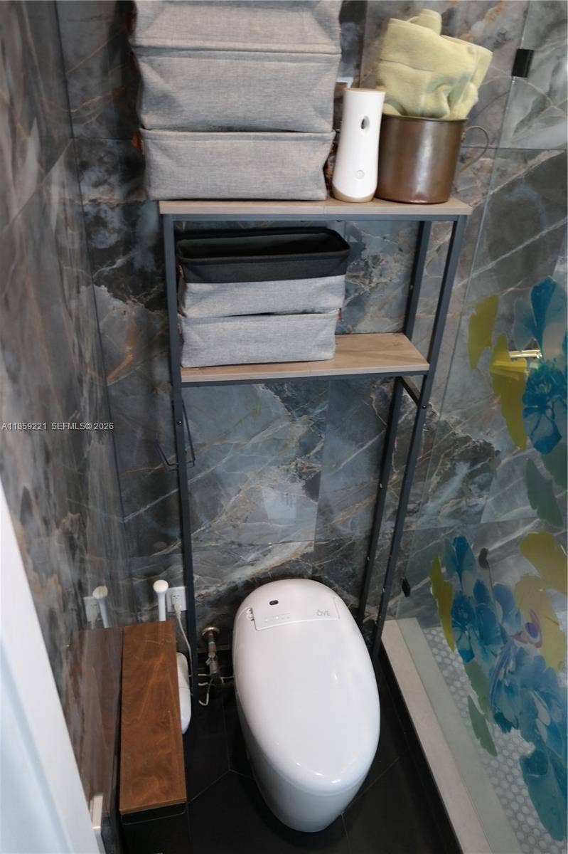 524 NE 27th Drive, Wilton Manors, FL 33334 Elegant private bathroom, offering a smart toilet and a large walk-in shower with low-threshold entry for a seamless daily routine