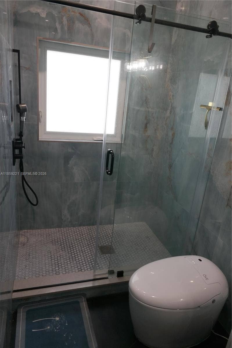 524 NE 27th Drive, Wilton Manors, FL 33334 Walk-in shower with barn-style glass sliding doors for a luxurious daily routine