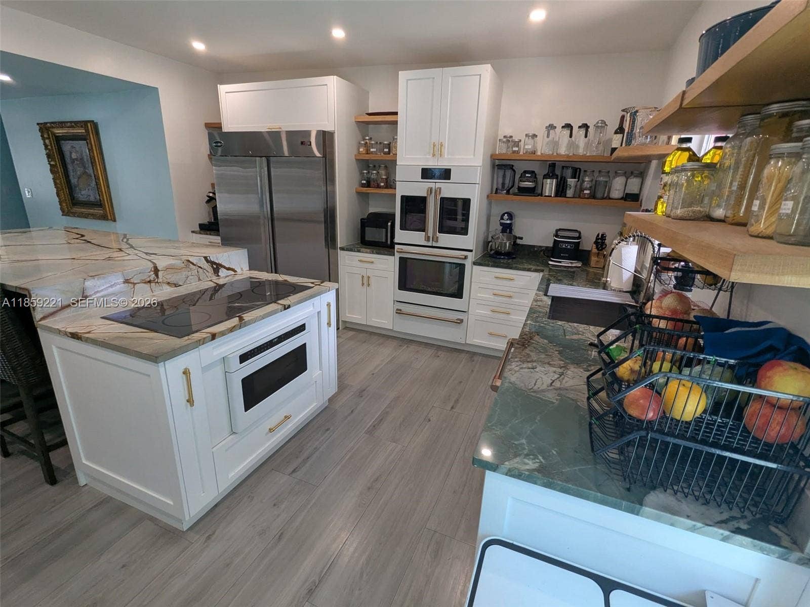 524 NE 27th Drive, Wilton Manors, FL 33334 Tasteful white-finished lighting and hardware enhance the kitchens elegant ambiance with subtle, stylish detail