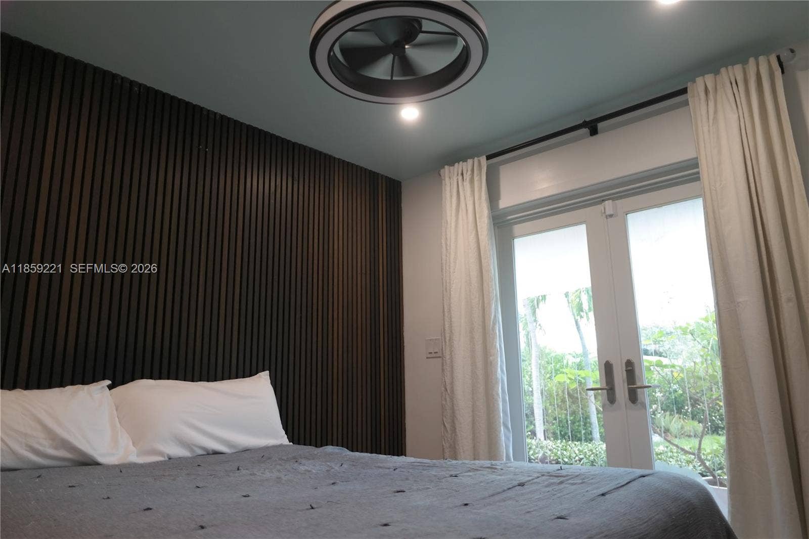 524 NE 27th Drive, Wilton Manors, FL 33334 Well-appointed room featuring a closet, modern ceiling fan, and French door access to the landscaped front yard