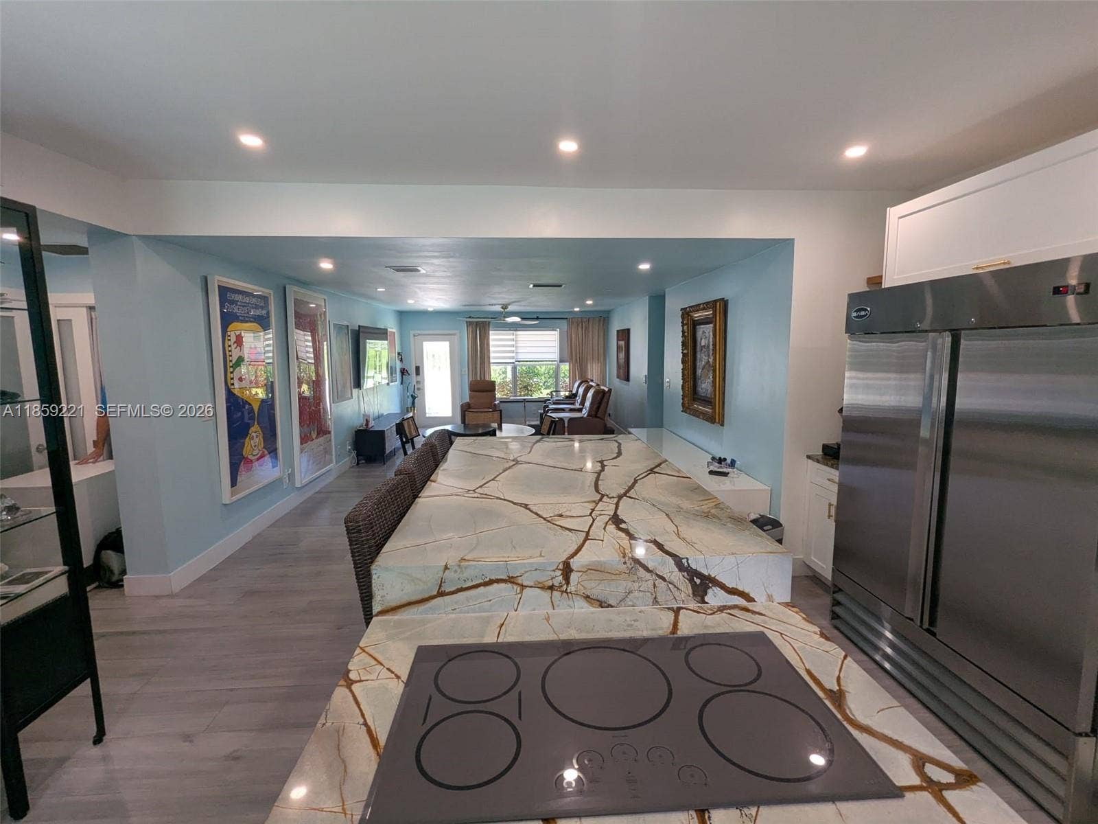 524 NE 27th Drive, Wilton Manors, FL 33334 Elegant glass burners pair beautifully with the dual-level quartz waterfall island, blending form and function in a refined kitchen design, perfect for entertaining.