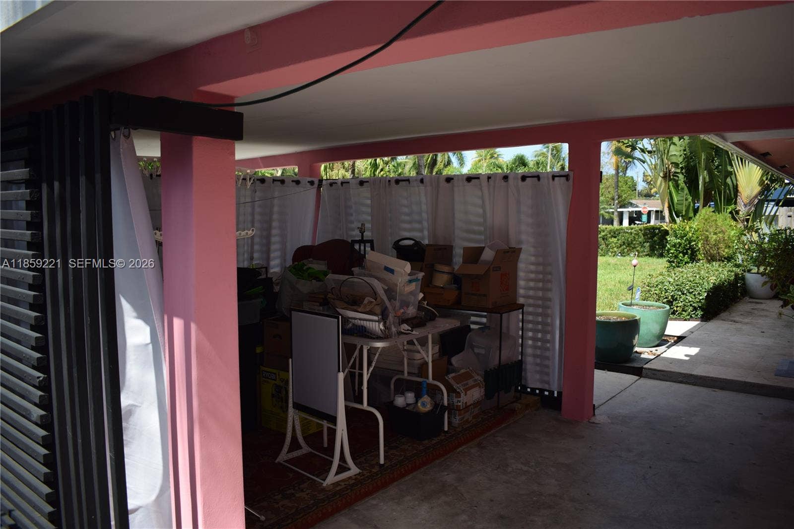 524 NE 27th Drive, Wilton Manors, FL 33334 Enjoy the versatility of a covered carport transformed into a stylish multi-use area, ideal for creative work, fitness, or bar area.