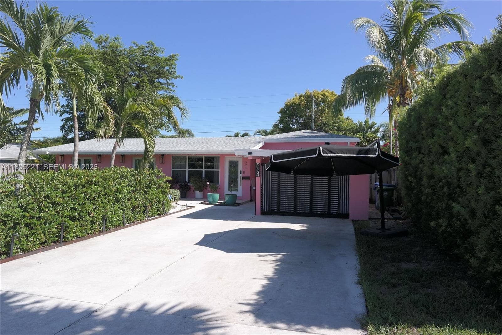 524 NE 27th Drive, Wilton Manors, FL 33334 Soft lighting woven through manicured hedges creates a charming, well-lit walkway leading to the entrance