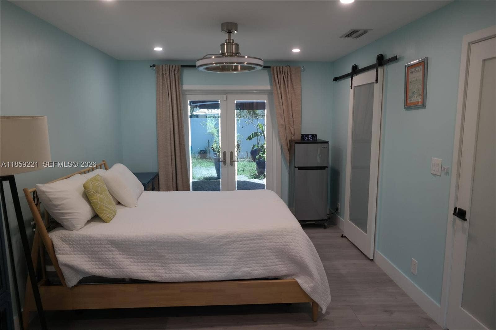 524 NE 27th Drive, Wilton Manors, FL 33334 Spacious primary room with dual ceiling fans and two sets of French doorsone opening to the front of the home, the other to the private backyard