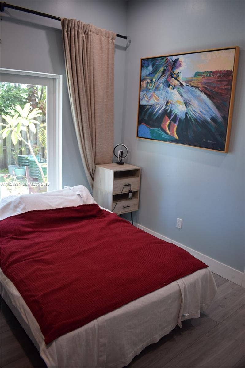 524 NE 27th Drive, Wilton Manors, FL 33334 Charming bedroom opening to the patio, complemented by a luxurious en-suite bath featuring bold celeste finishes