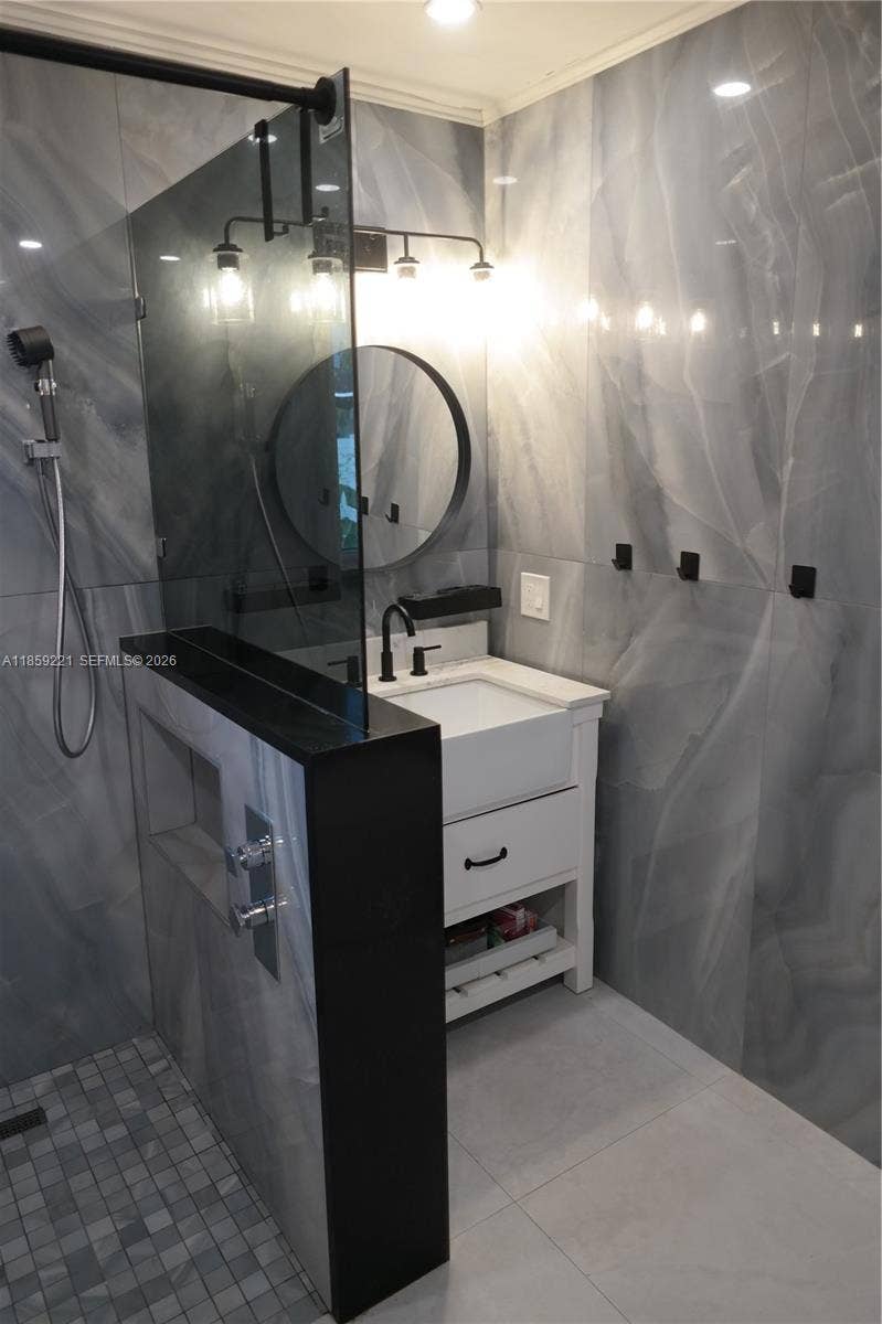524 NE 27th Drive, Wilton Manors, FL 33334 Expansive shared bathroom featuring a spa-style walk-in shower, two separate deep sink vanities, and dual smart toilets.