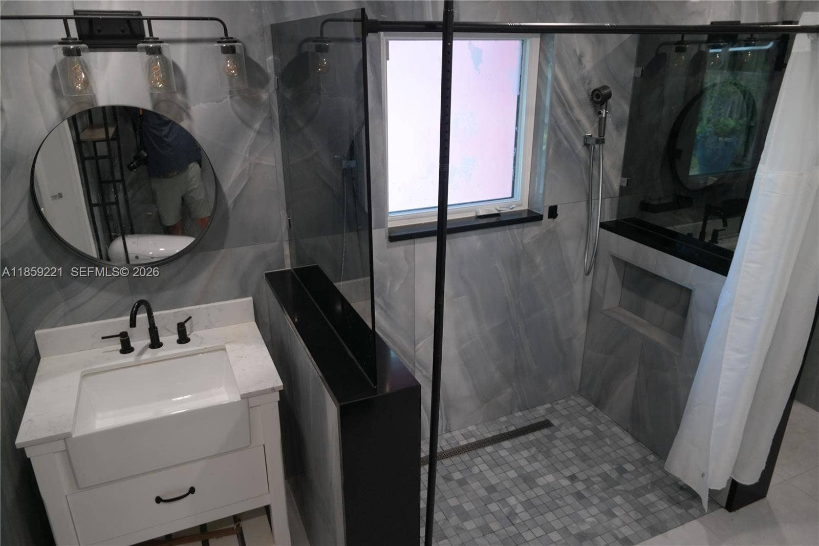 524 NE 27th Drive, Wilton Manors, FL 33334 Expansive shared bathroom featuring a spa-style floor-level walk-in shower, two separate deep sink vanities, and dual smart toiletsdesigned for comfort, privacy, and modern living.