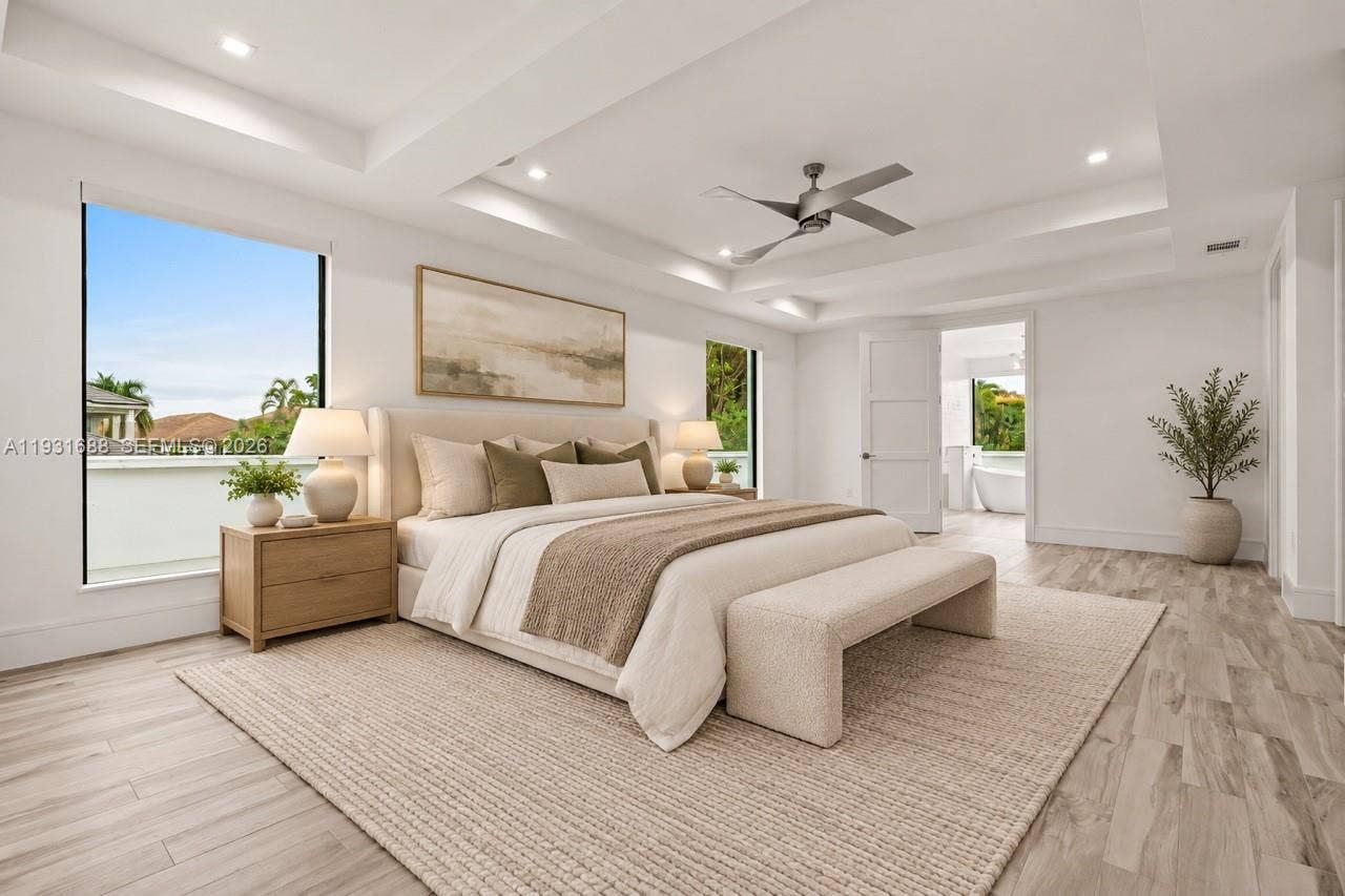 Tray ceiling with recessed lighting, wood-finish flooring, and ceiling fan