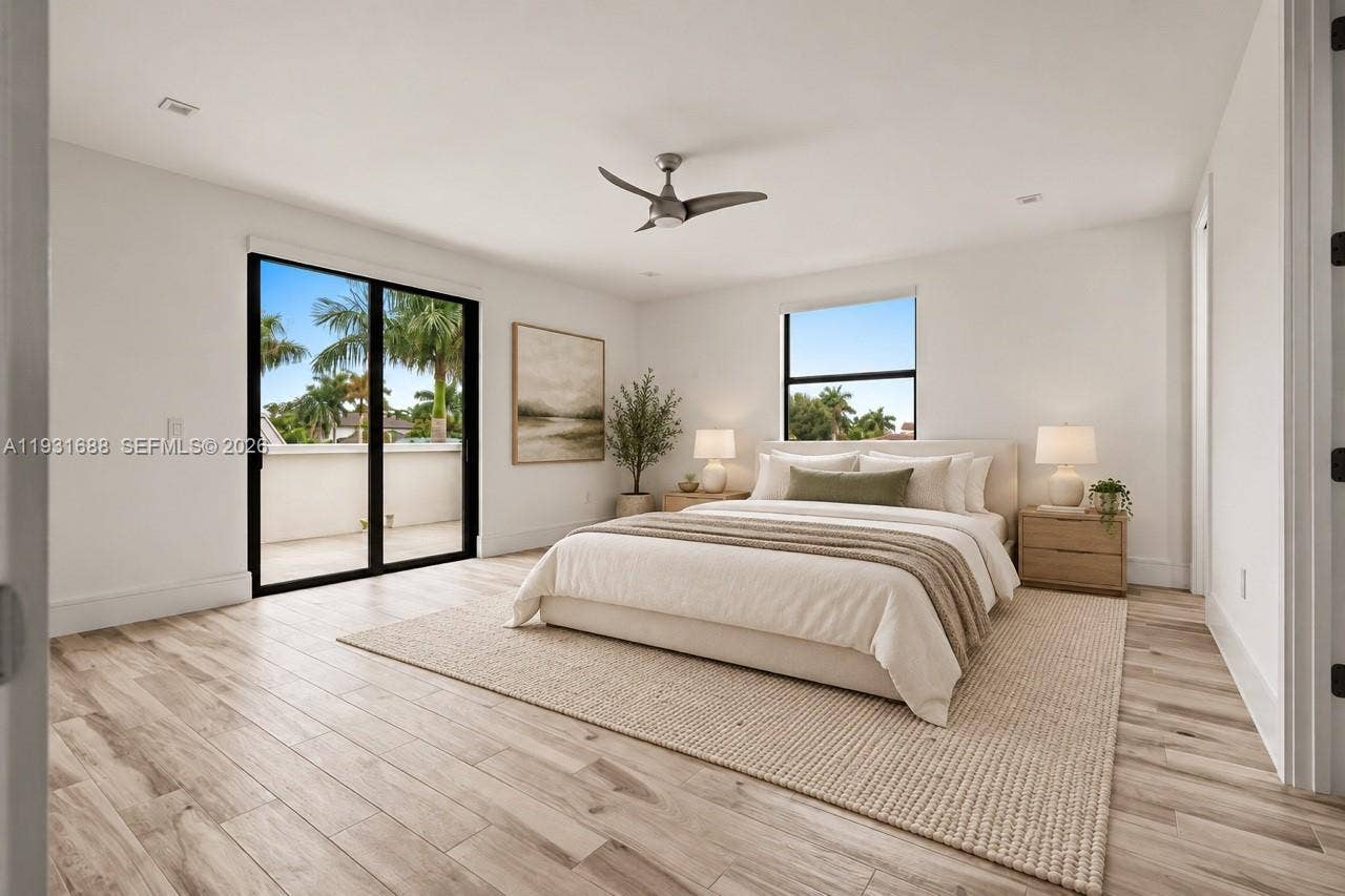 Room featuring light wood-finish flooring, recessed lighting, a modern ceiling fan, and black-framed glass sliding doors opening to a balcony