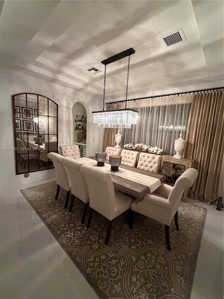 MAIN DINING ROOM WITH DOUBLE TRAY CEILING, DECORATED WITH A DESIGNER GLASS CHANDELIER