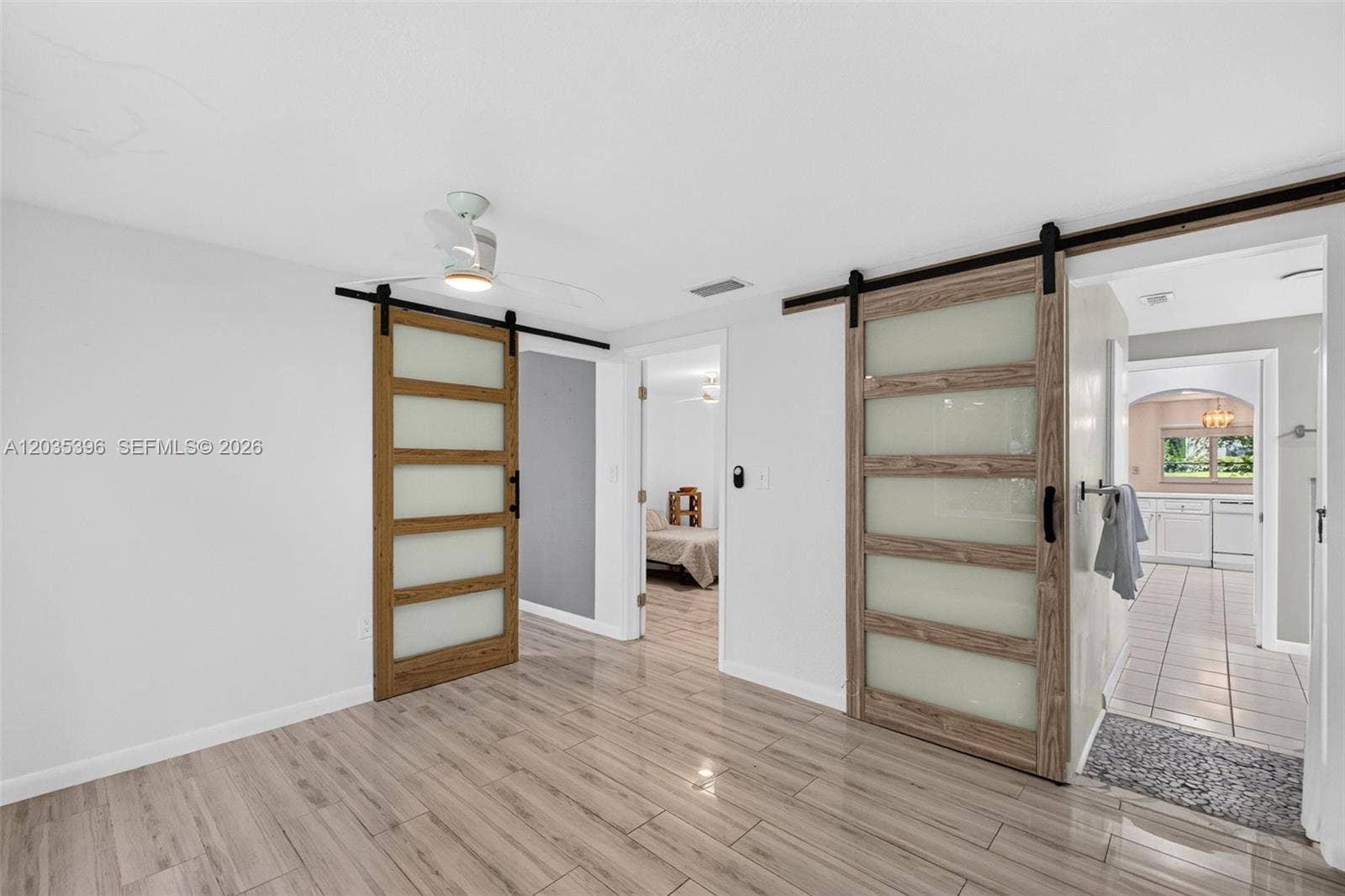 Second bedroom in Guest House with closet. One barn door provides access to a bonus room / office / 3rd bedroom in the guest house. The other leads to the bathroom and toward the kitchen. Middle door is toward first bedroom