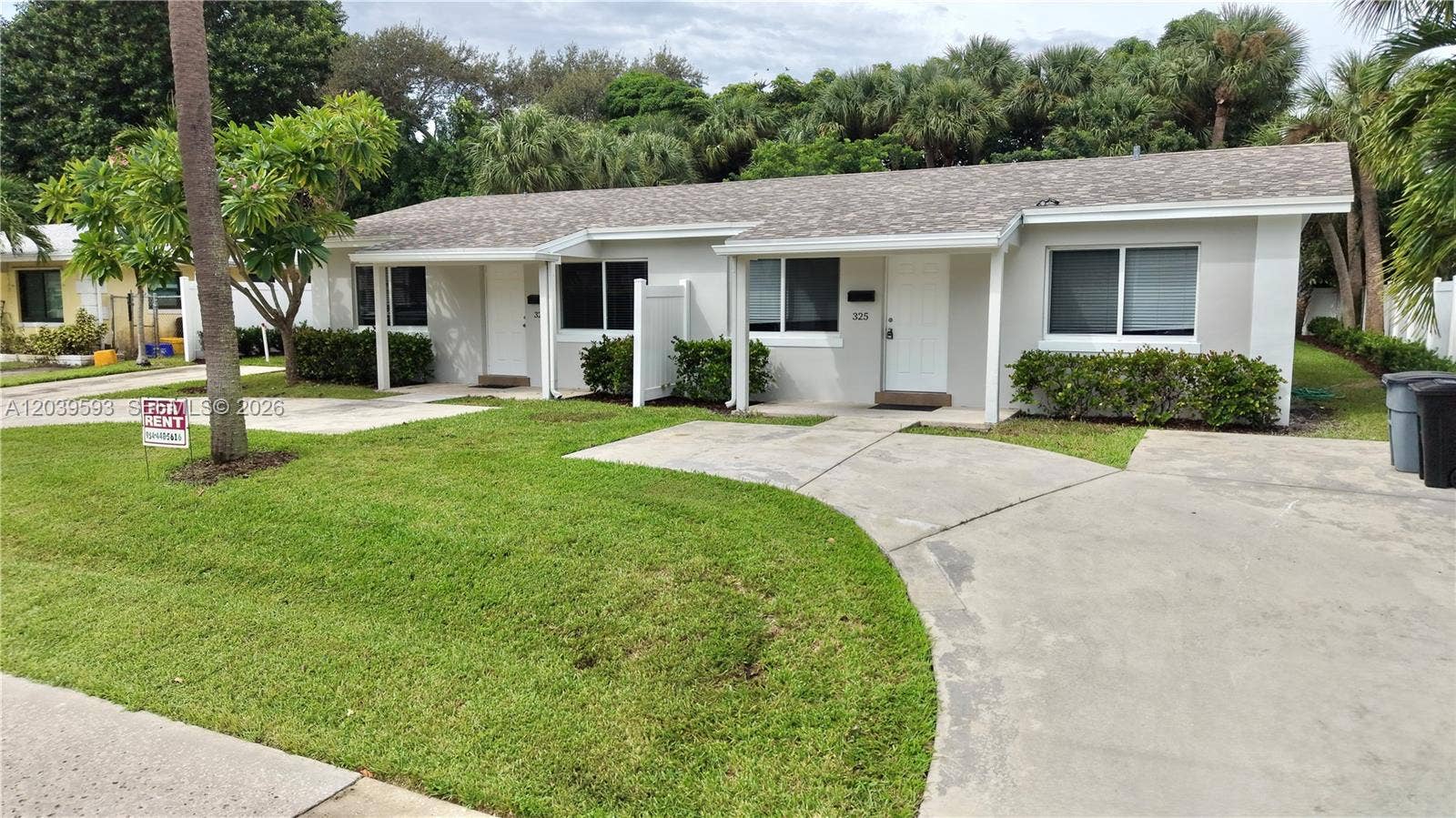 Single-story duplex featuring a neutral stucco exterior, low-pitch shingle roof, concrete driveway, and manicured landscaping