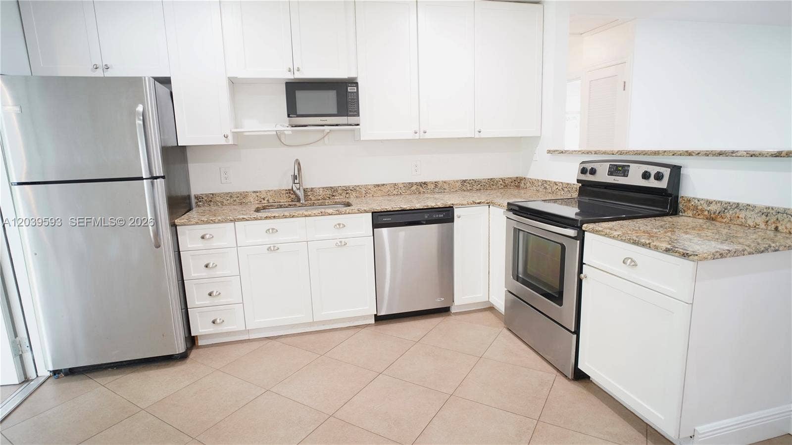 Kitchen featuring white cabinetry, stone-finish countertops, stainless steel appliances, and tile flooring