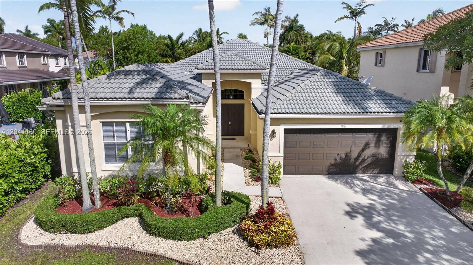 786 Nandina Drive, Weston, FL 33327 Impressive curb appeal with lush tropical landscaping and majestic palms.