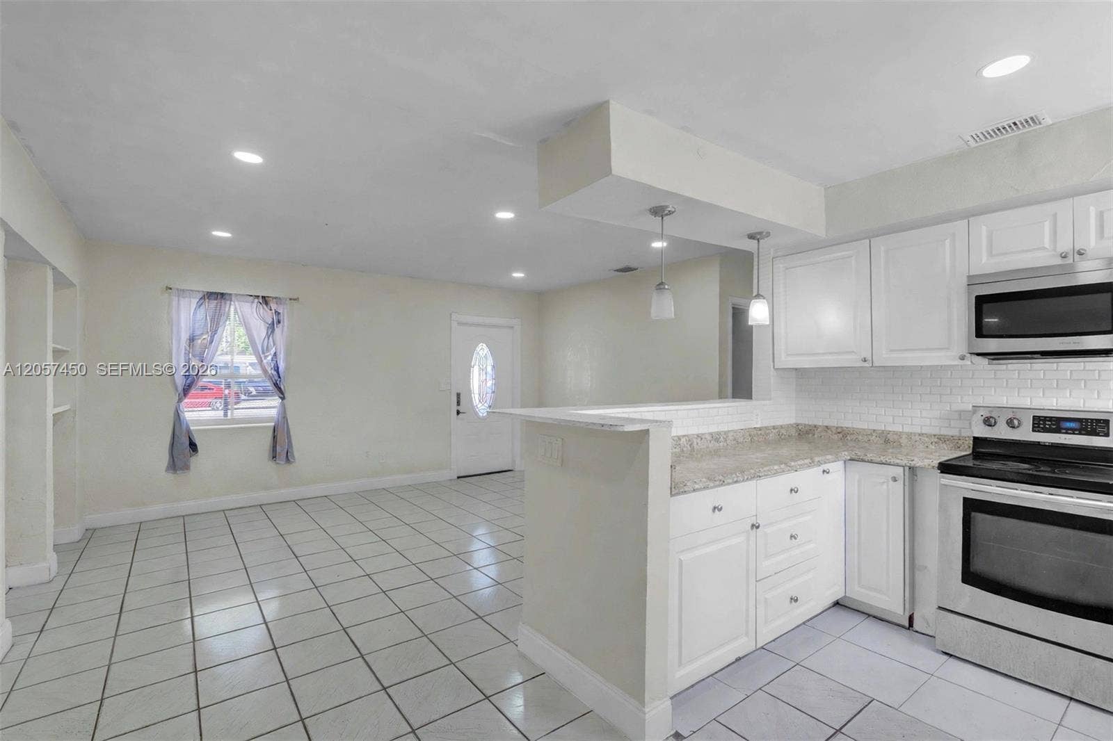 Kitchen featuring white cabinetry, stone-finish countertops, subway tile backsplash, stainless steel appliances, and recessed lighting throughout the area