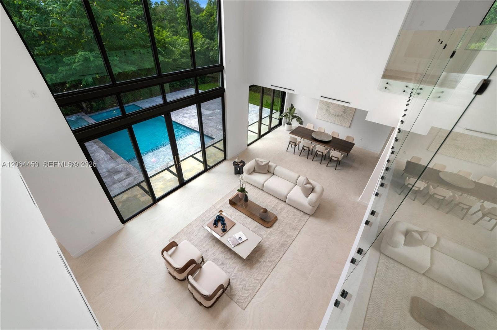 View from the upper level overlooking the great room and pool beyond the glass