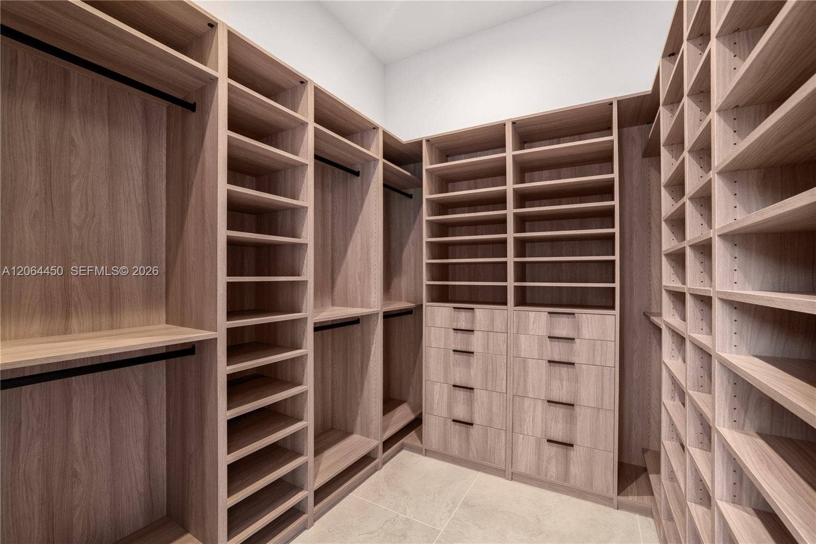 Custom walk in closet with extensive wood shelving and drawer storage