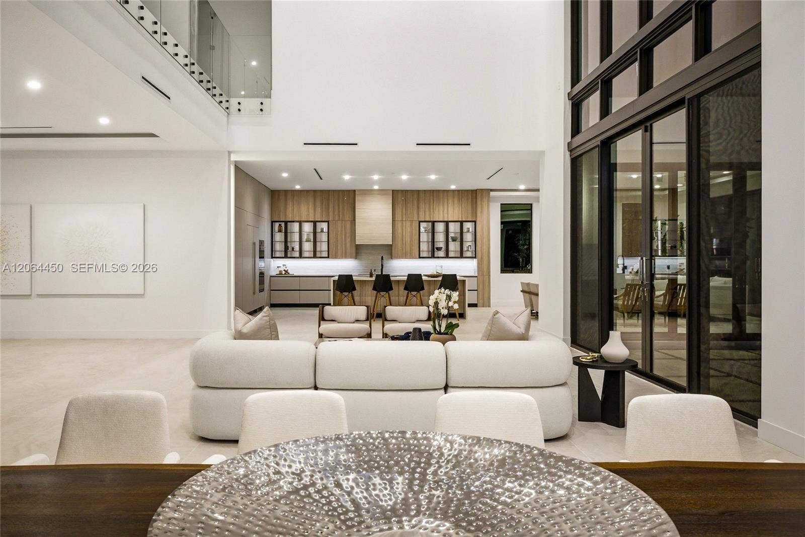 Living area opening to the kitchen with custom wood cabinetry and glass walls