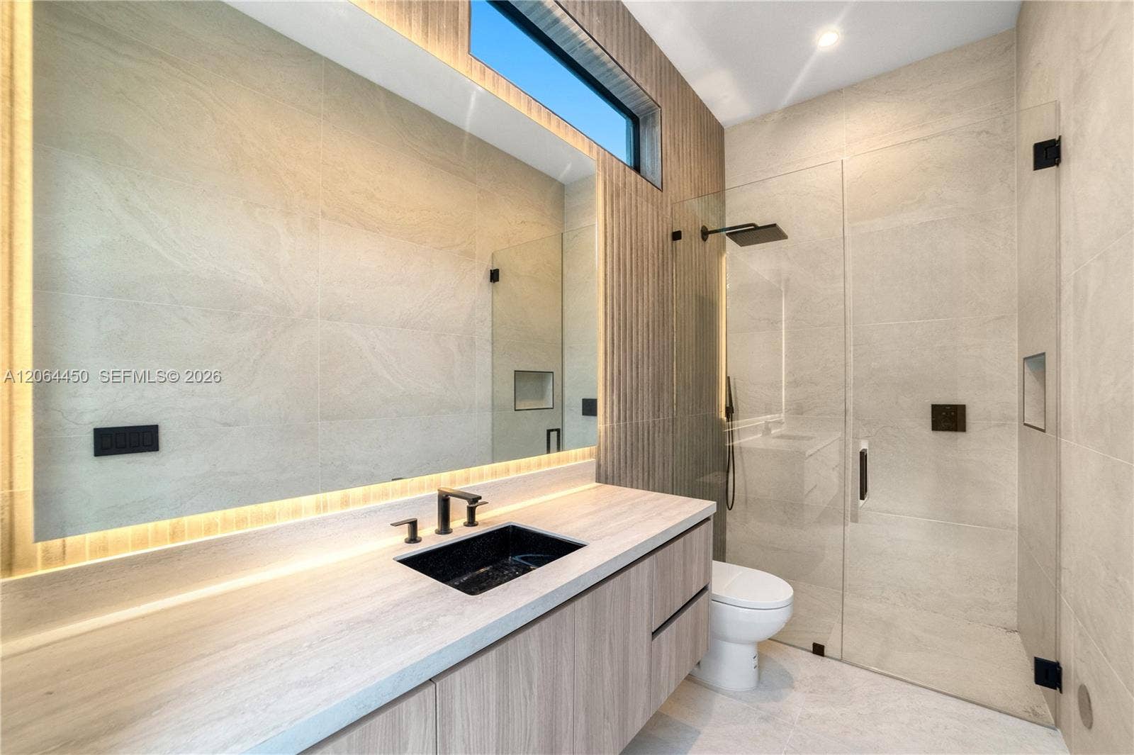Modern bath with floating vanity, large format tile, and frameless glass shower
