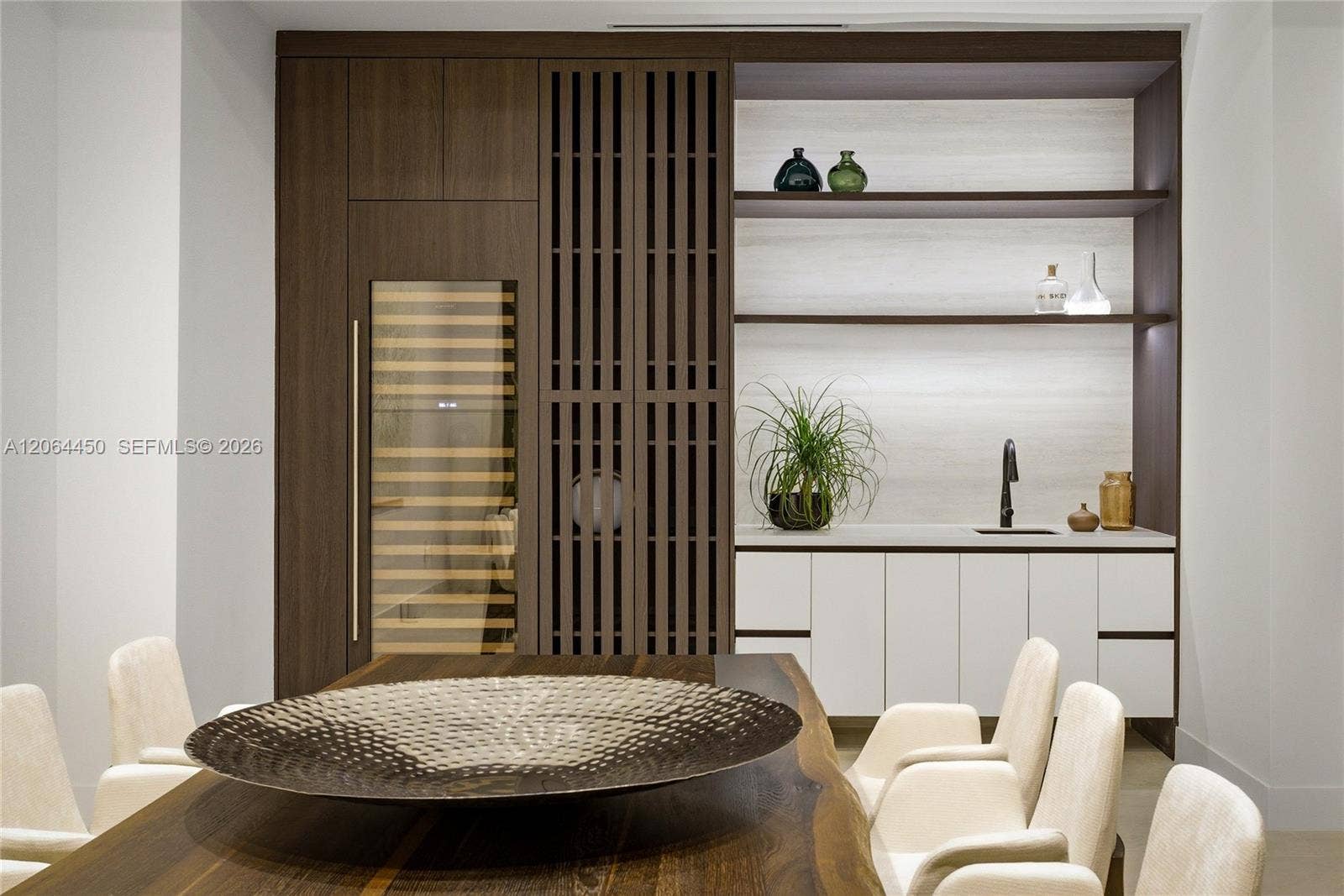 Dining area with custom wood slat feature wall and built in display shelving