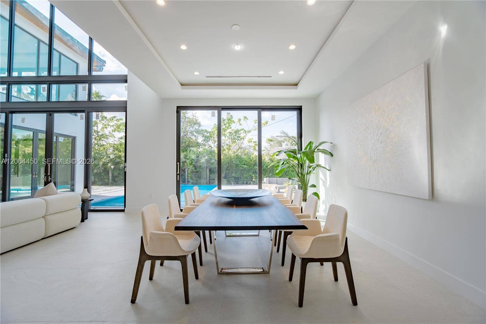 Formal dining area with pool views through floor to ceiling glass