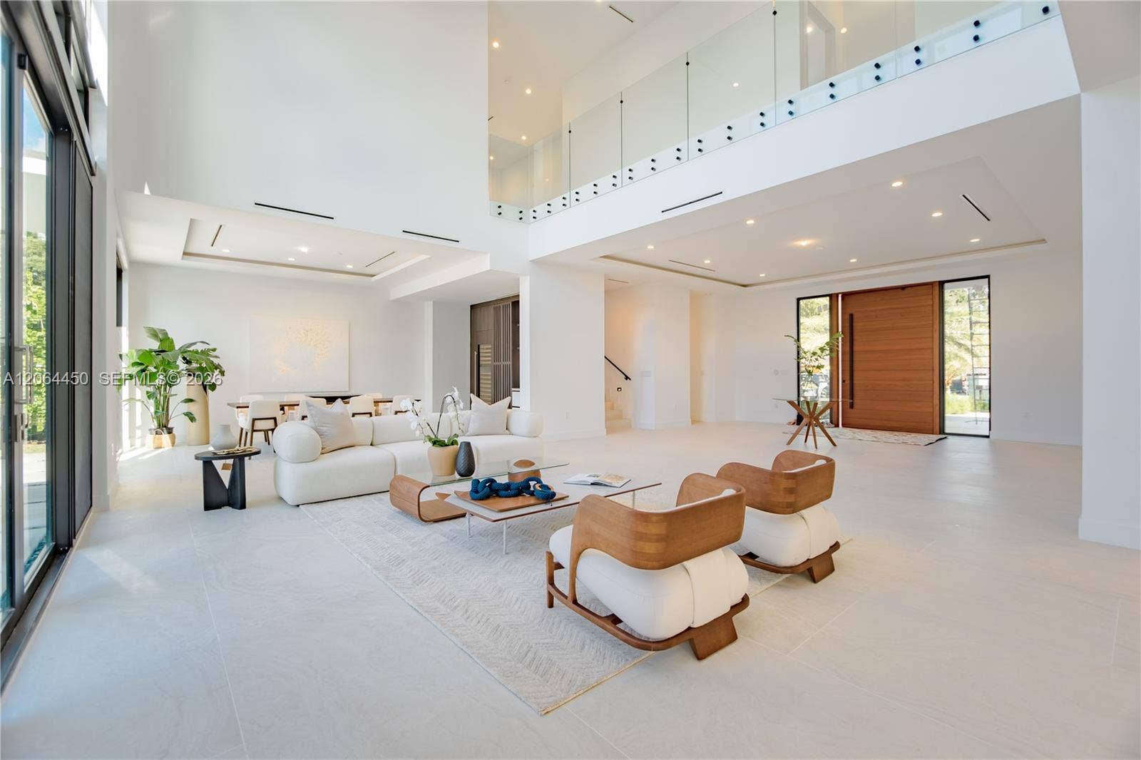 Open living space flowing toward the entry, with elegant seating and natural light