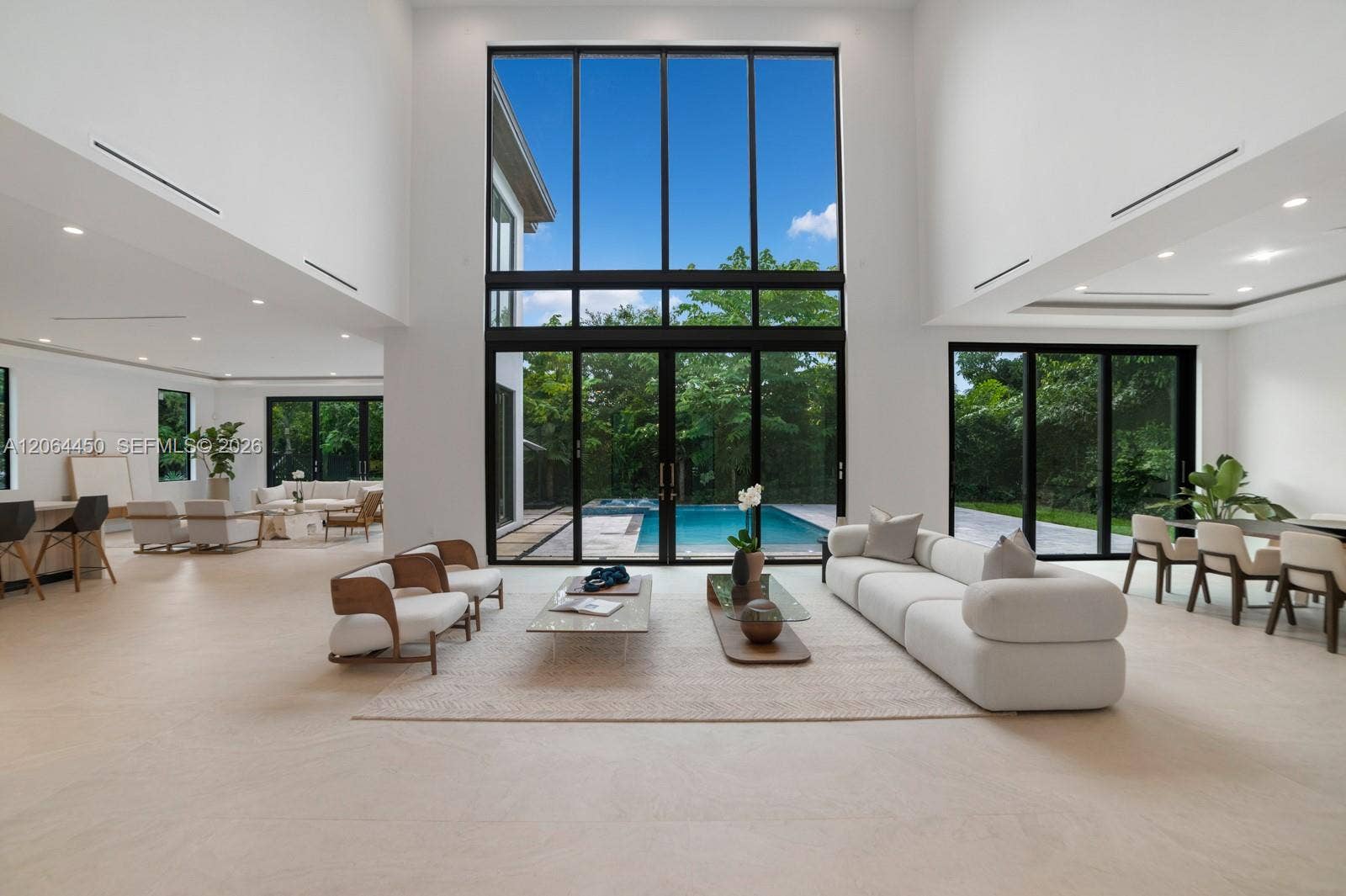 Double height great room with floor to ceiling glass overlooking the pool