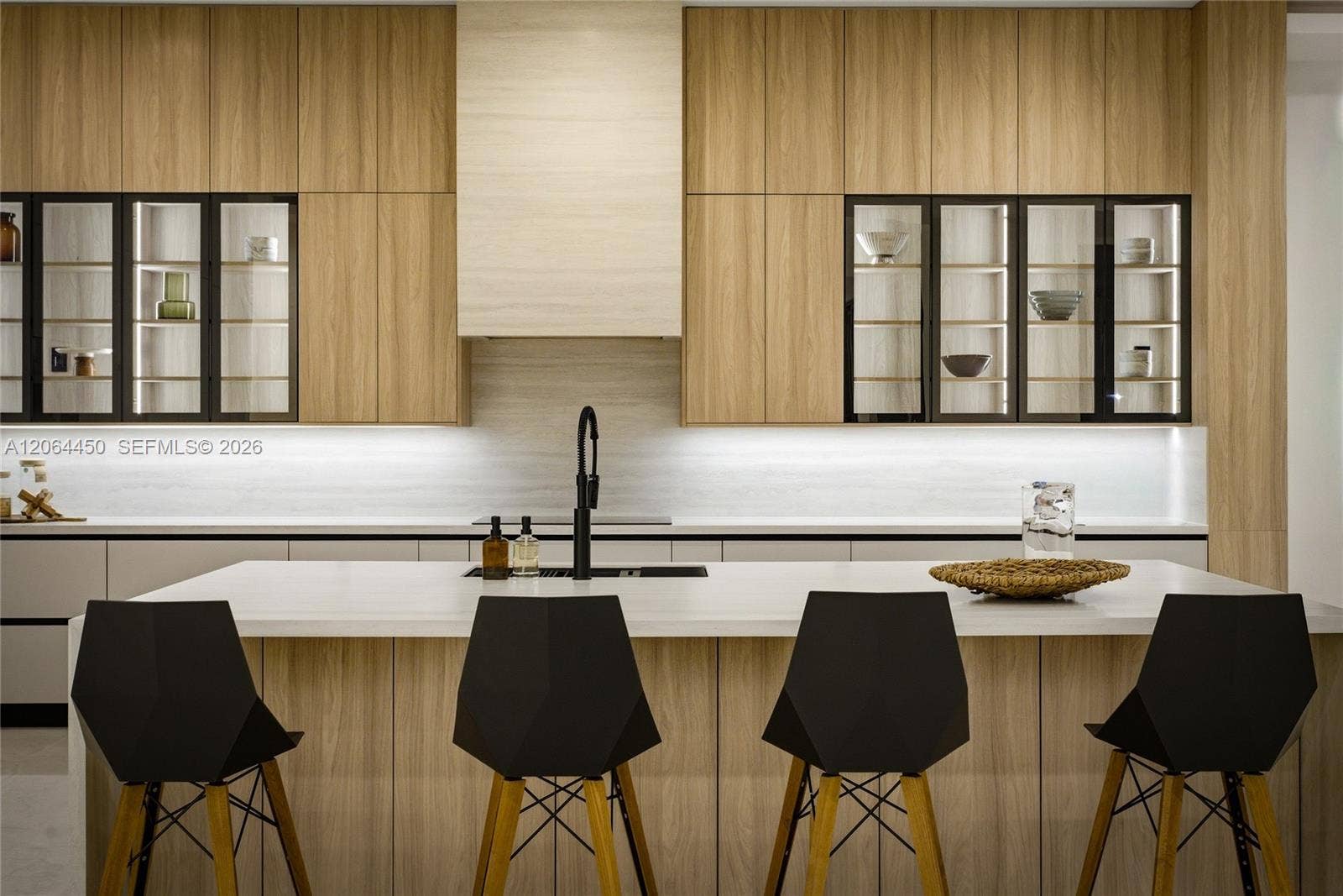Kitchen with waterfall island, bar seating, and integrated wood cabinetry