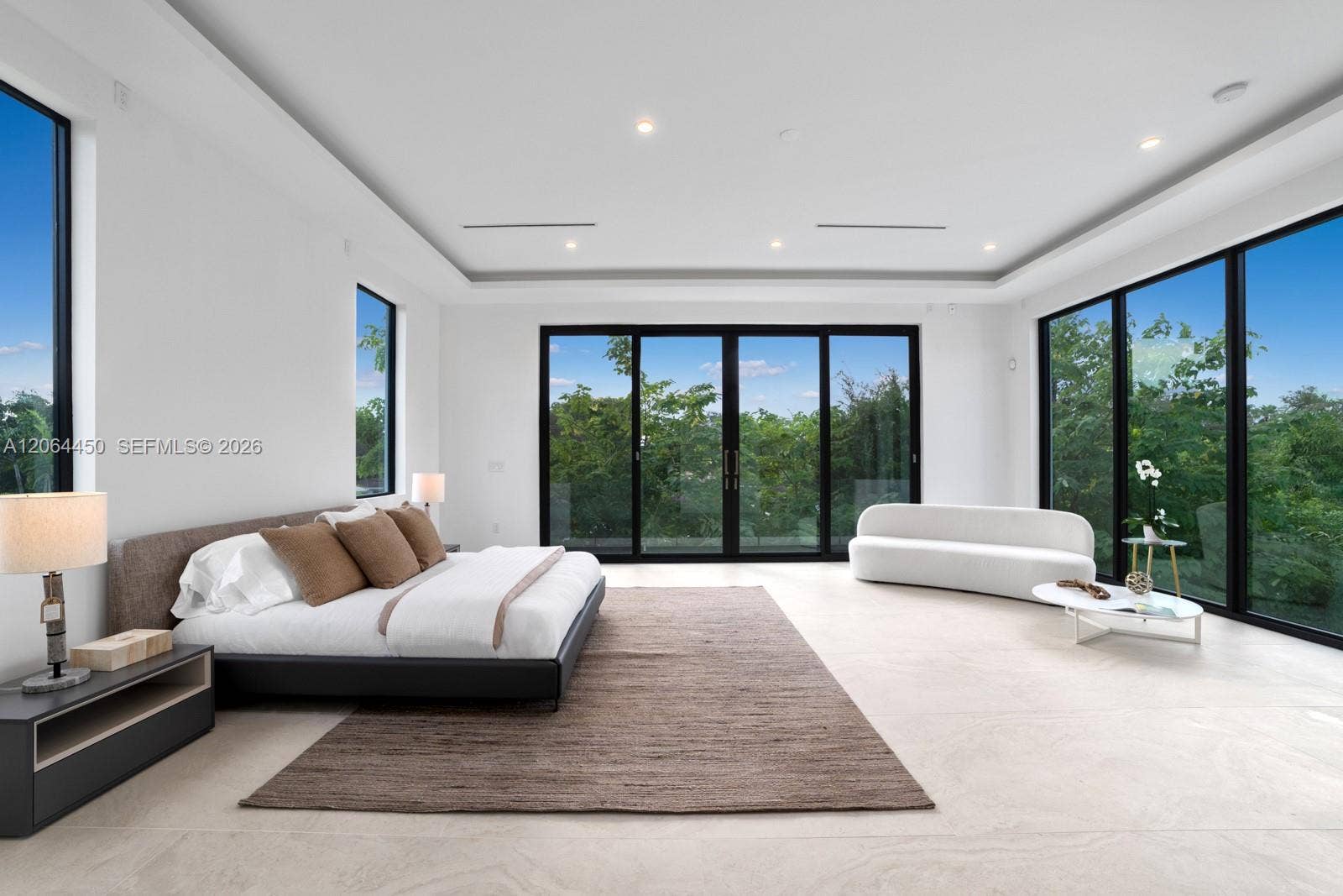 Spacious primary suite with a sitting area and panoramic garden views